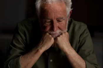 Sad elderly man reflecting on the loss of his teeth