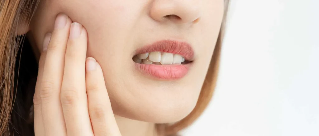 Patient experiencing persistent tooth sensitivity as one of the signs you need a dental checkup